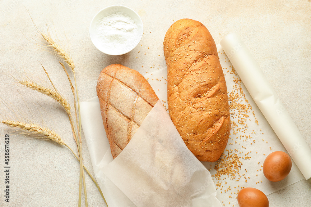 Baking paper with fresh bread on light background