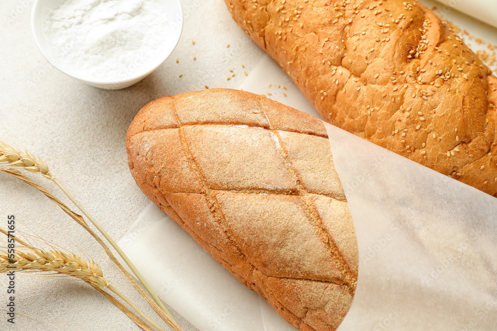 Baking paper with fresh bread on light background, closeup