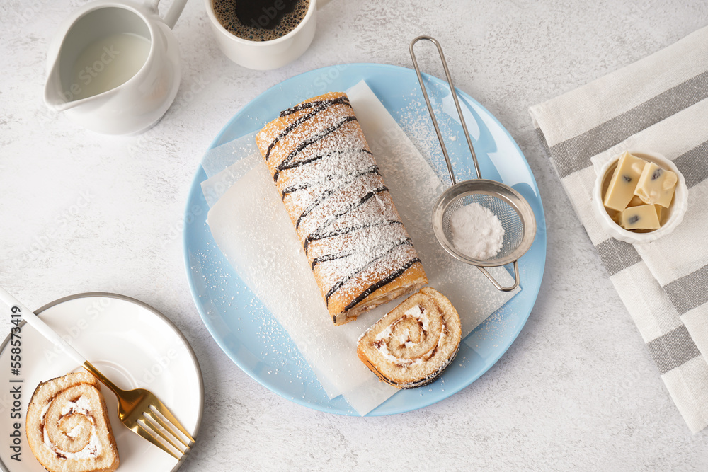 Blue plate with delicious sponge cake roll, chocolate and cup of coffee on white table