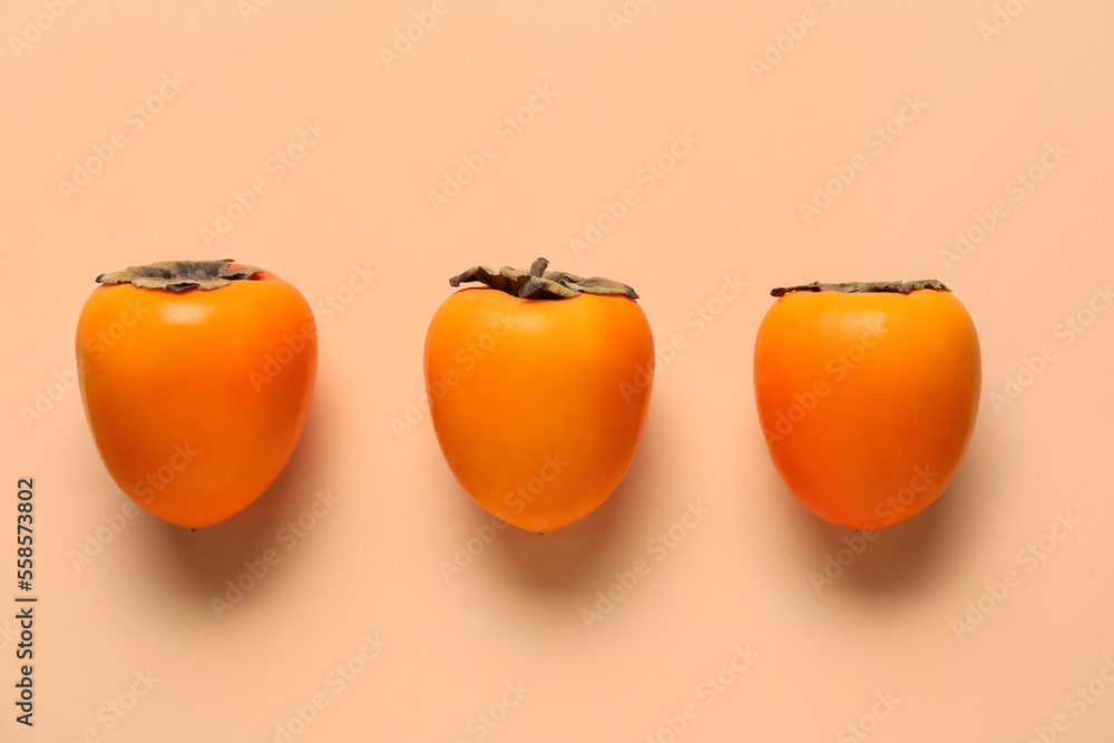 Fresh persimmons on color background