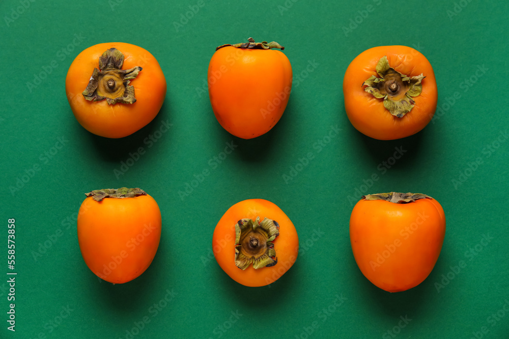 Fresh persimmons on green background