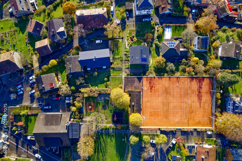 Top view of village Evilard Leubringen, Canton Bern, on a sunny autumn day with tennis court and res