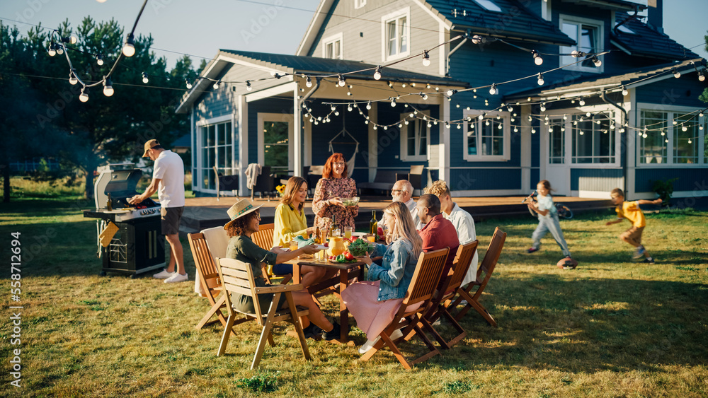 Parents, Children and Friends Gathered at a Barbecue Dinner Table Outside a Beautiful Home. Old and 