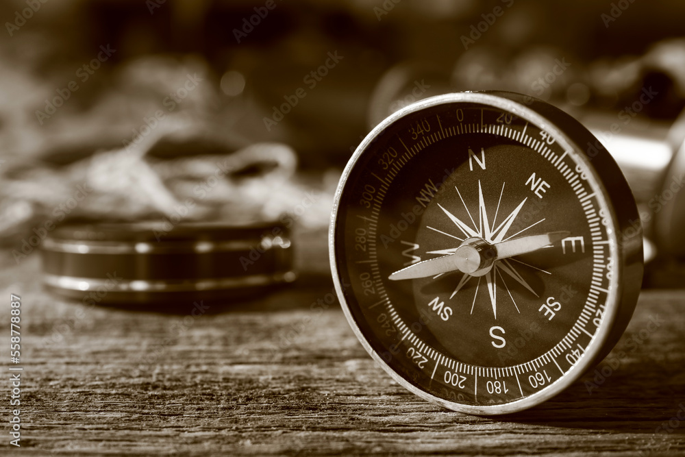 Retro compass on dark wooden background, closeup