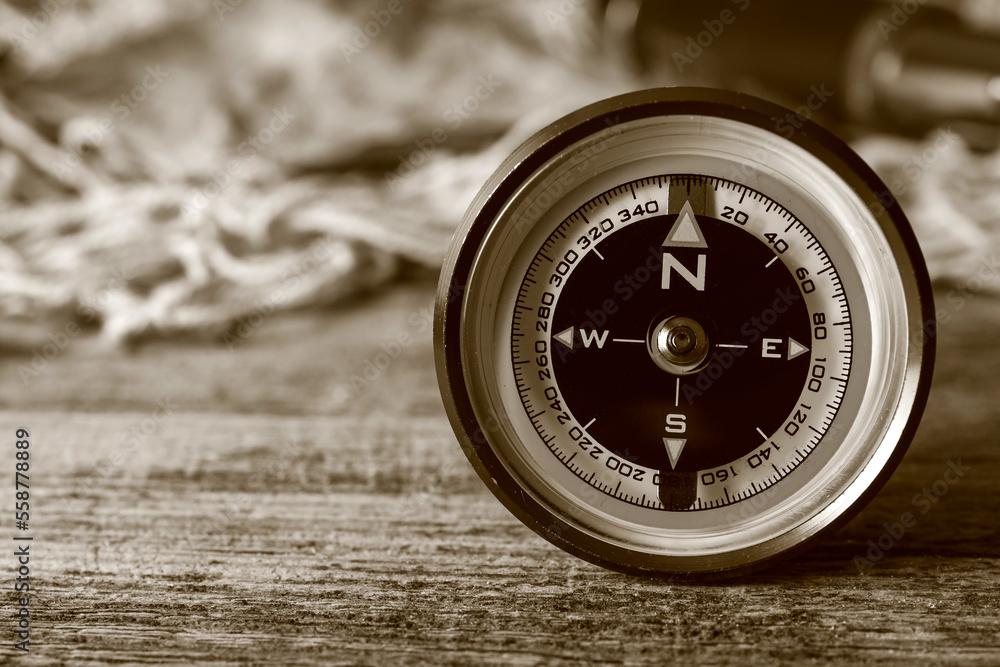 Retro compass on dark wooden background, closeup