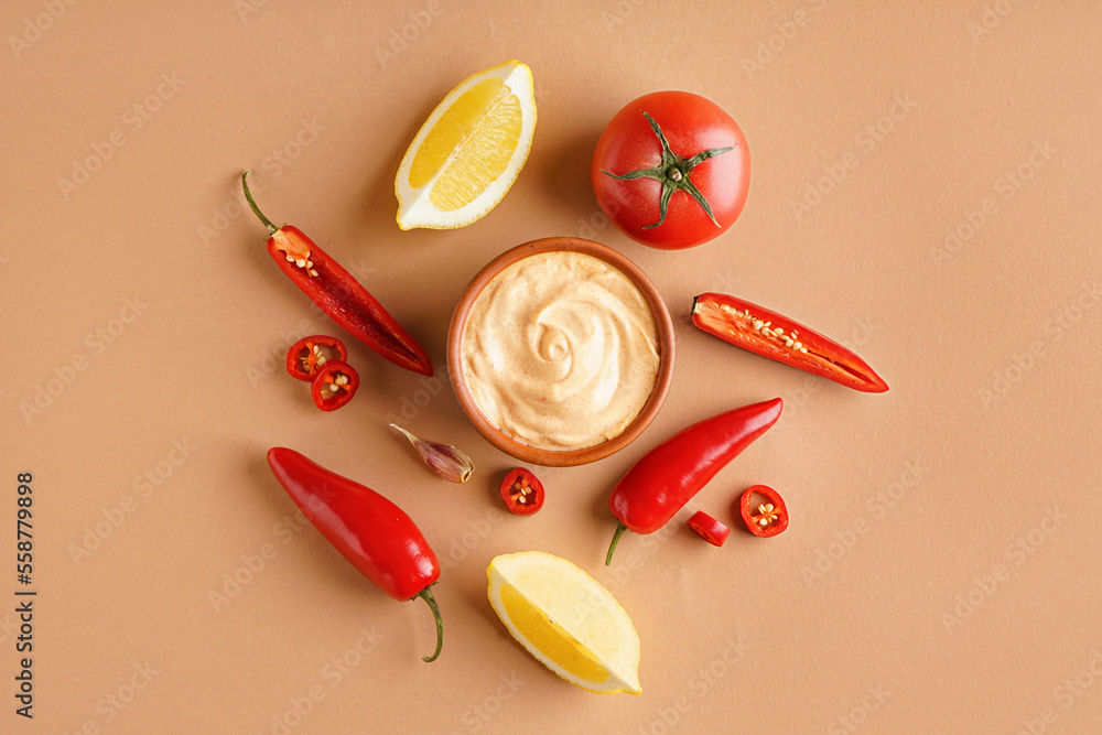 Bowl of tasty chipotle sauce and ingredients on color background