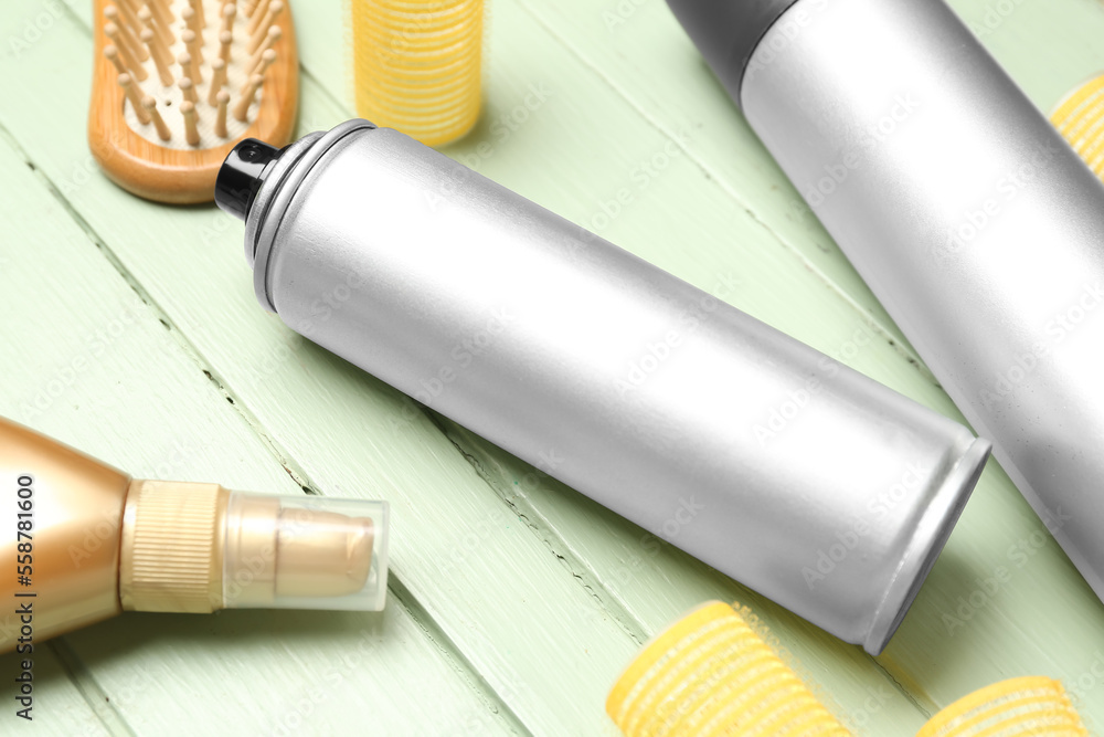 Hair spray on green wooden background, closeup