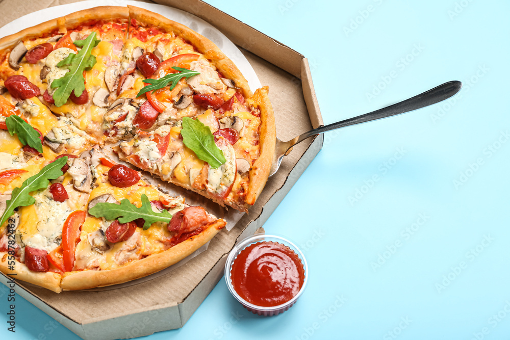 Cardboard box with tasty pizza and sauce on color background