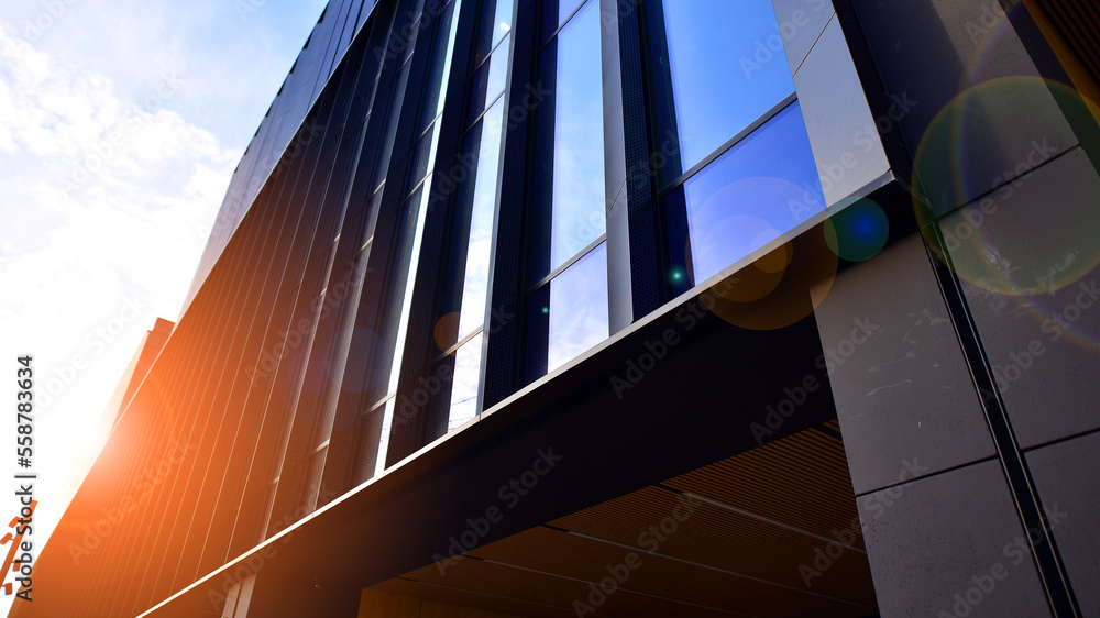 Glass modern building with blue sky background. Low angle view and architecture details. Urban abstr