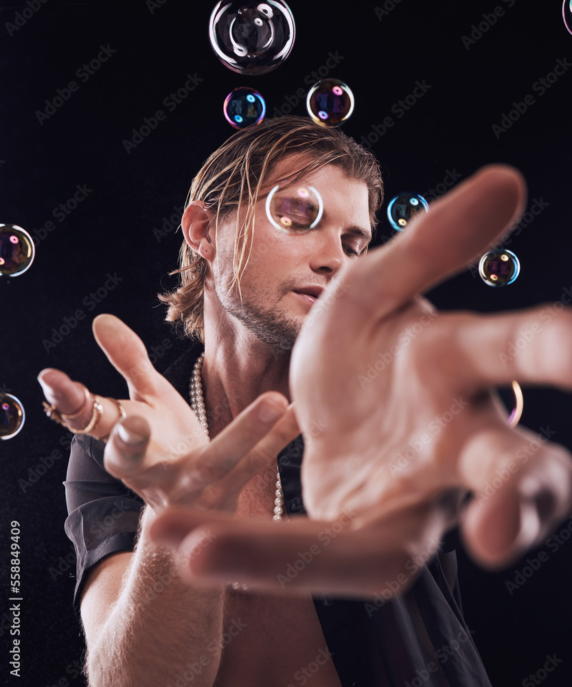 Man, hands and bubbles in studio for magic, art performance or creative show by black background. Mo