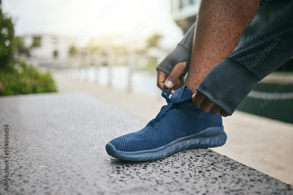 Hands, fitness and black man tie shoes in city and getting ready for running, workout or exercise. S