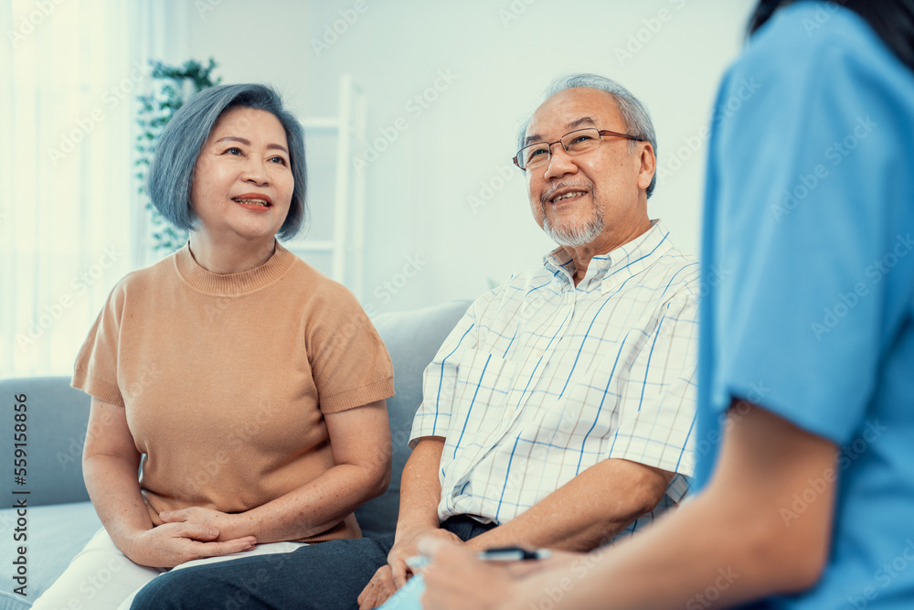 Female doctor visiting a contented elderly couple at their home. Health care, senior health support 