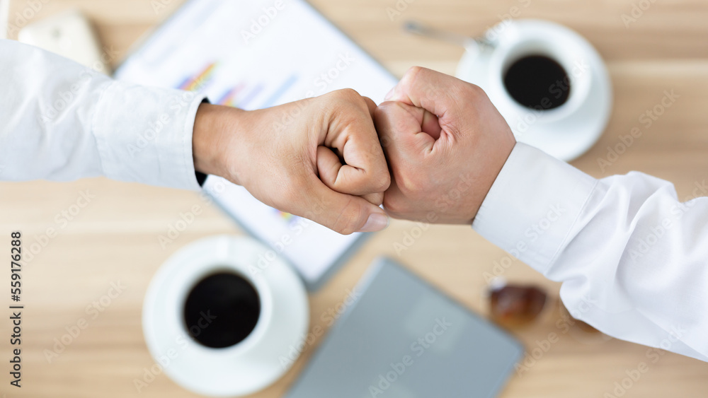 Top view of two men touch knuckles hands, Businessman fist bump hand after success meeting talk, Fis