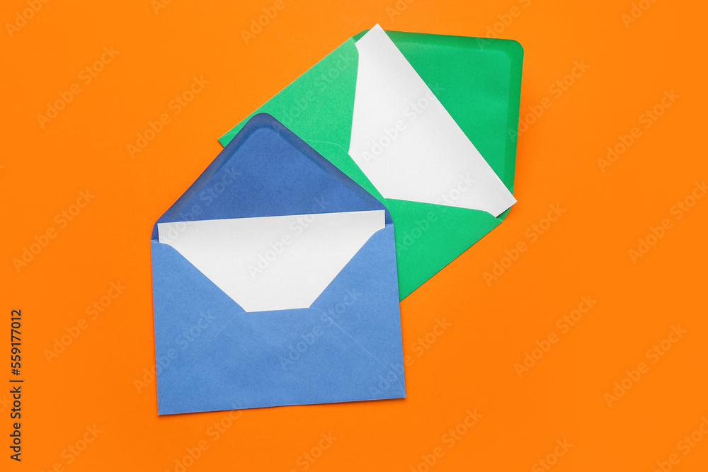 Paper envelopes with cards on orange background