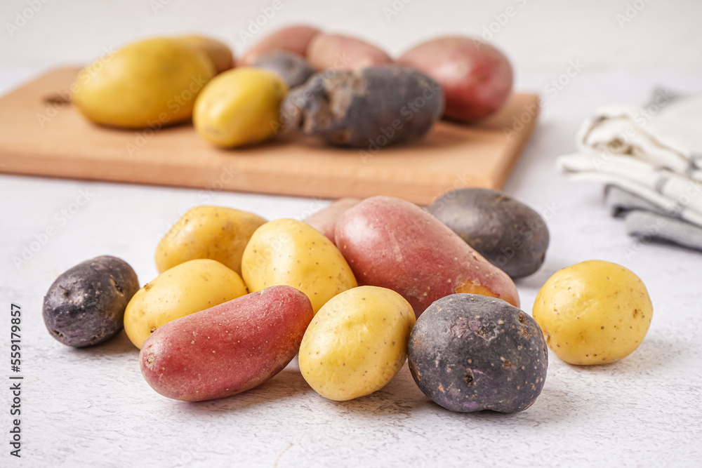 Heap of raw potatoes on light background