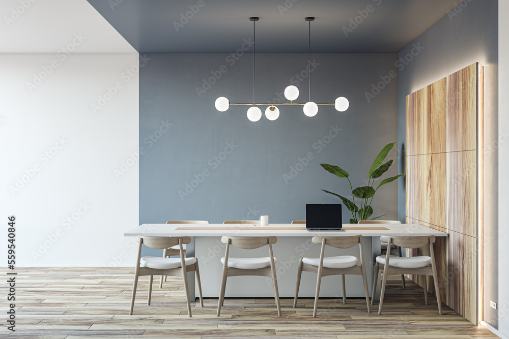 Front view on light conference table with laptop and chairs around on parquet floor in spacious meet