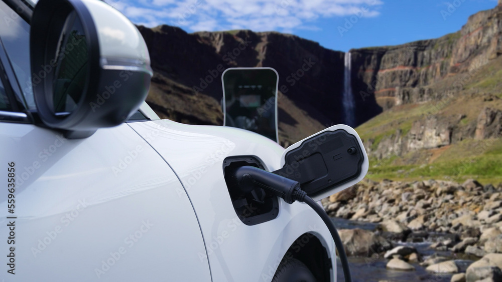 Electric car charging energy from charging station in the natural scenery, waterfall and stream back