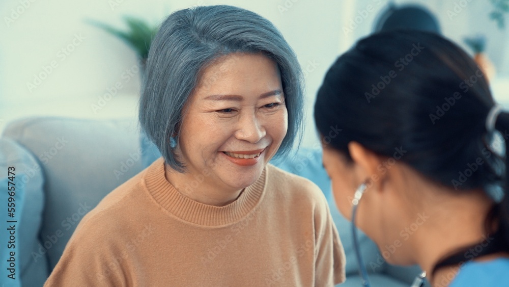 A contented retired senior woman being exterminated by her caregiver with a stethoscope at home. Med