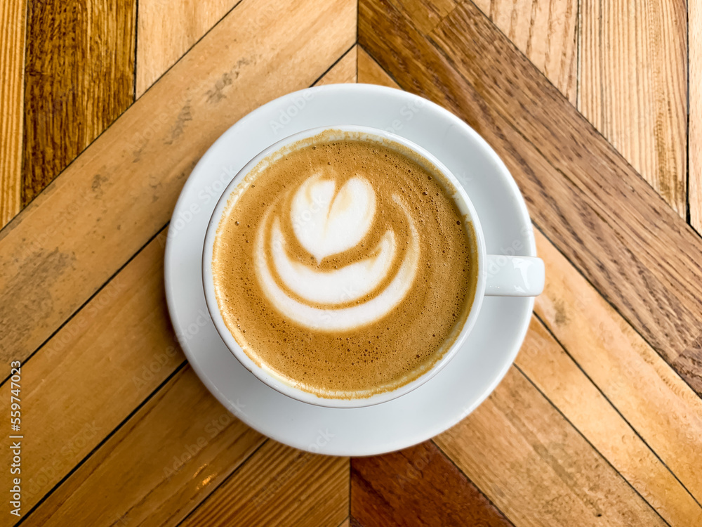 A cup of coffee latte on a wooden table. A mug of flat white coffee, latte, cappuccino on a wooden b