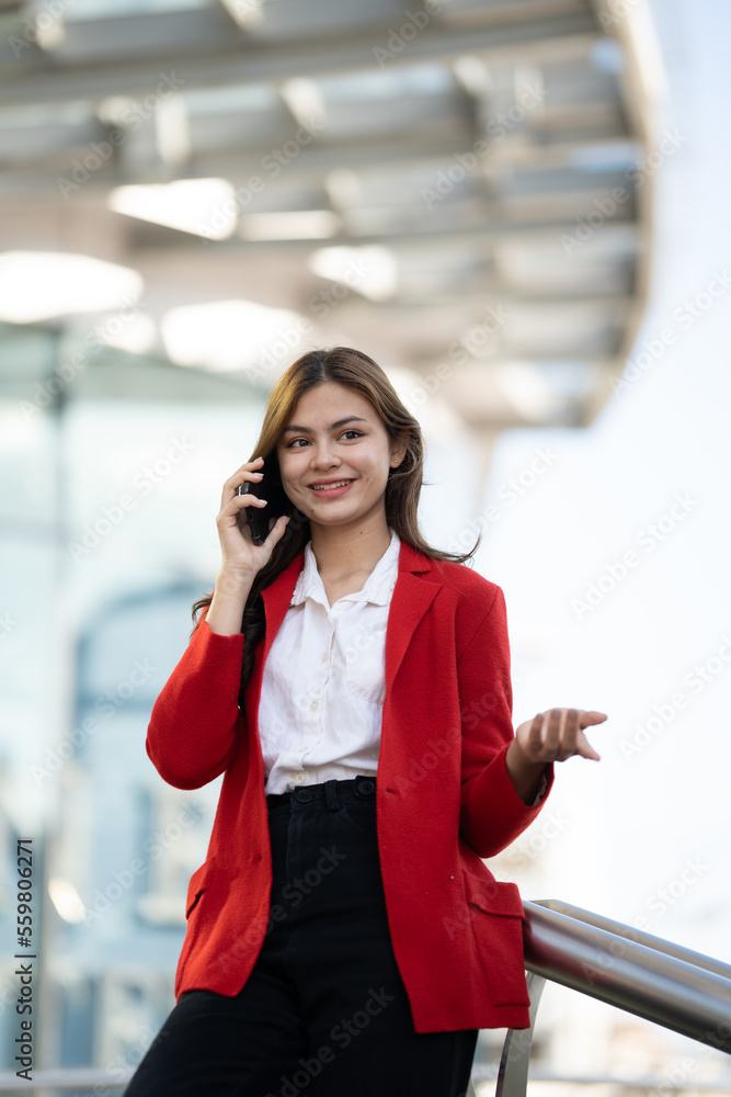 年轻的亚洲女商人在办公室使用智能手机。