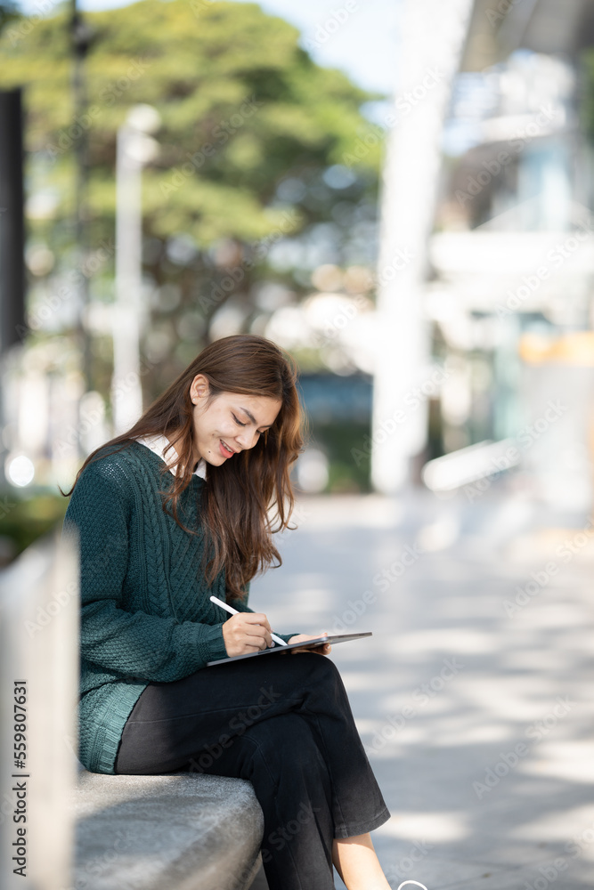 Asian woman student with tablet pc at school.