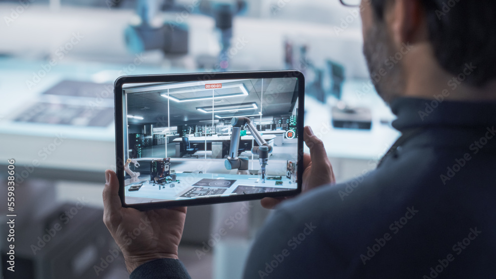 Over the Shoulder Shot of a Robotics Engineer Using a Tablet Computer Running Augmented Reality Soft