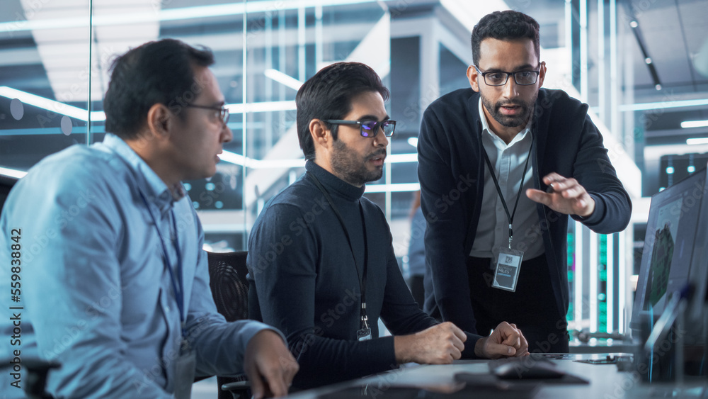 Team of Three Handsome Talented Young Engineers Use Computer to Discuss a Technological Project in I