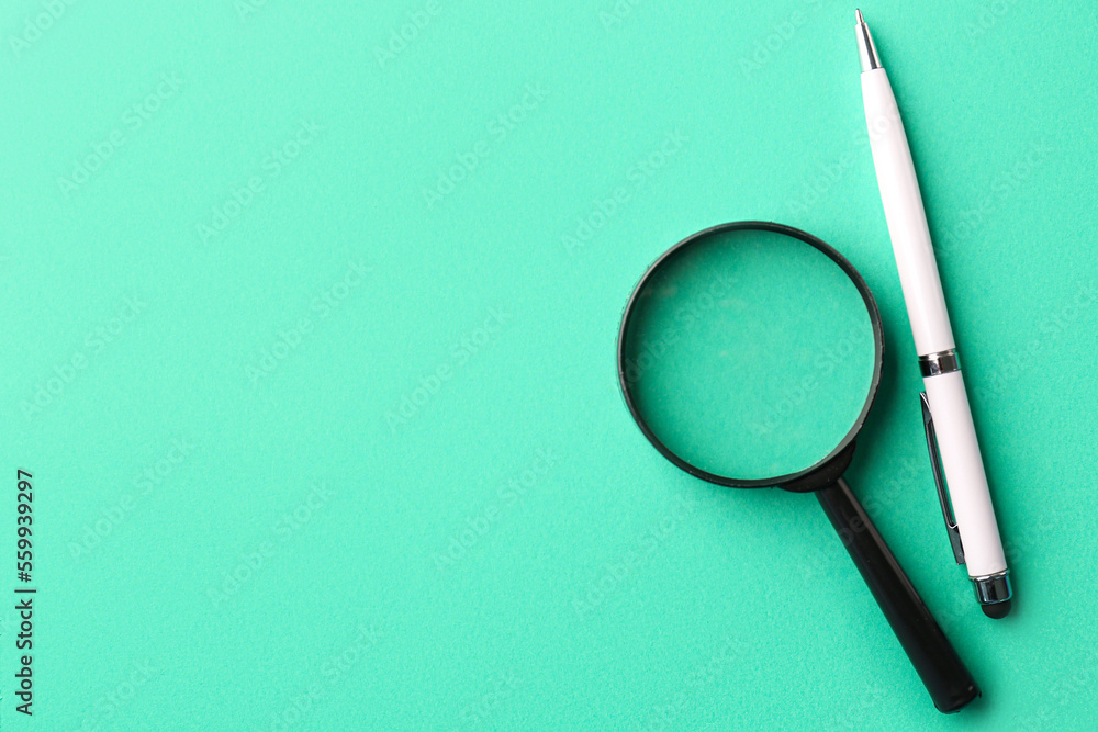 Pen and magnifier on color background