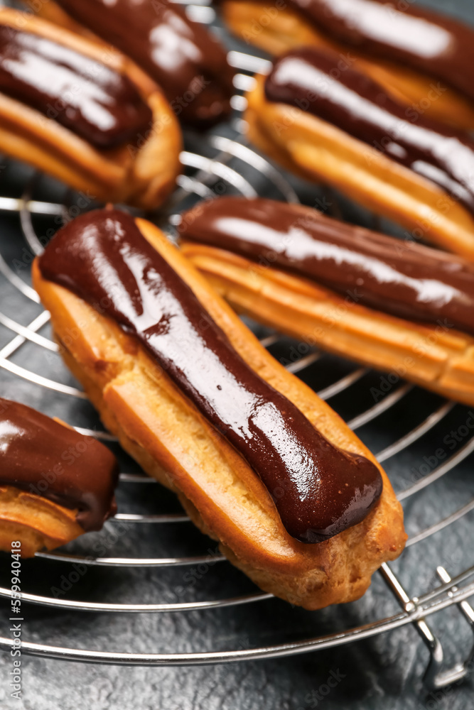 Grid with tasty chocolate eclairs on dark color background