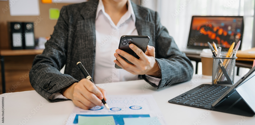  woman using tablet while sitting on cellphone at home. Beautiful girl relaxing while chatting on mo