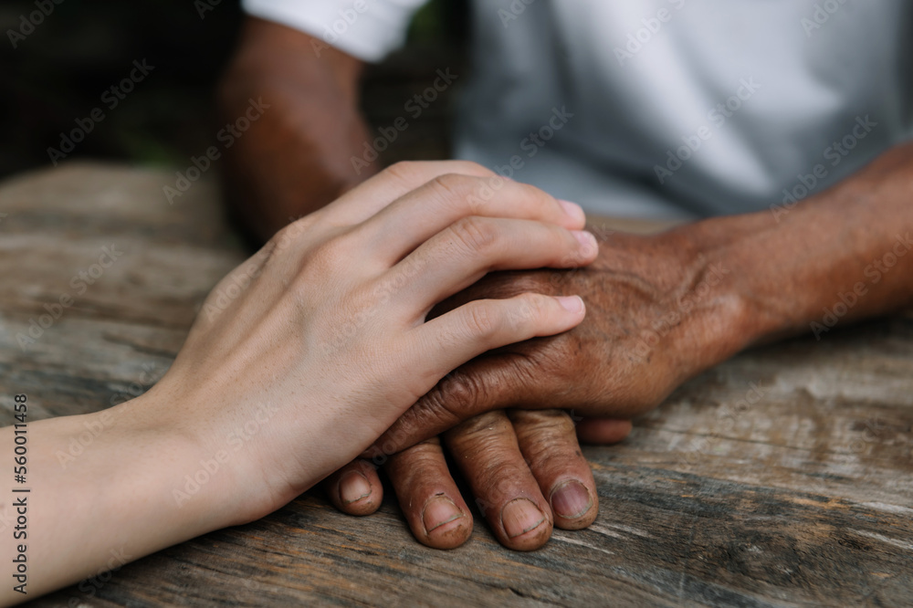 Young man holding senior woman hands, closeup