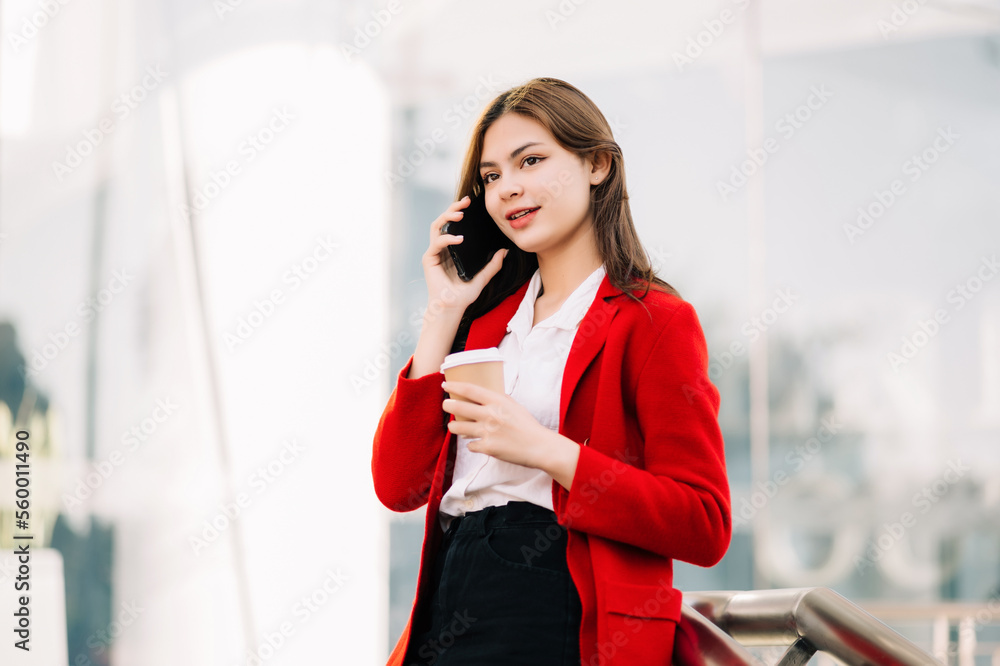 Beautiful female businesswoman use smartphone and holding laptop computer, Walk enjoy smiling while 