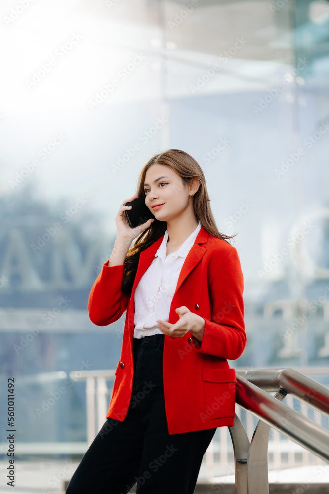 Beautiful female businesswoman use smartphone and holding laptop computer, Walk enjoy smiling while 