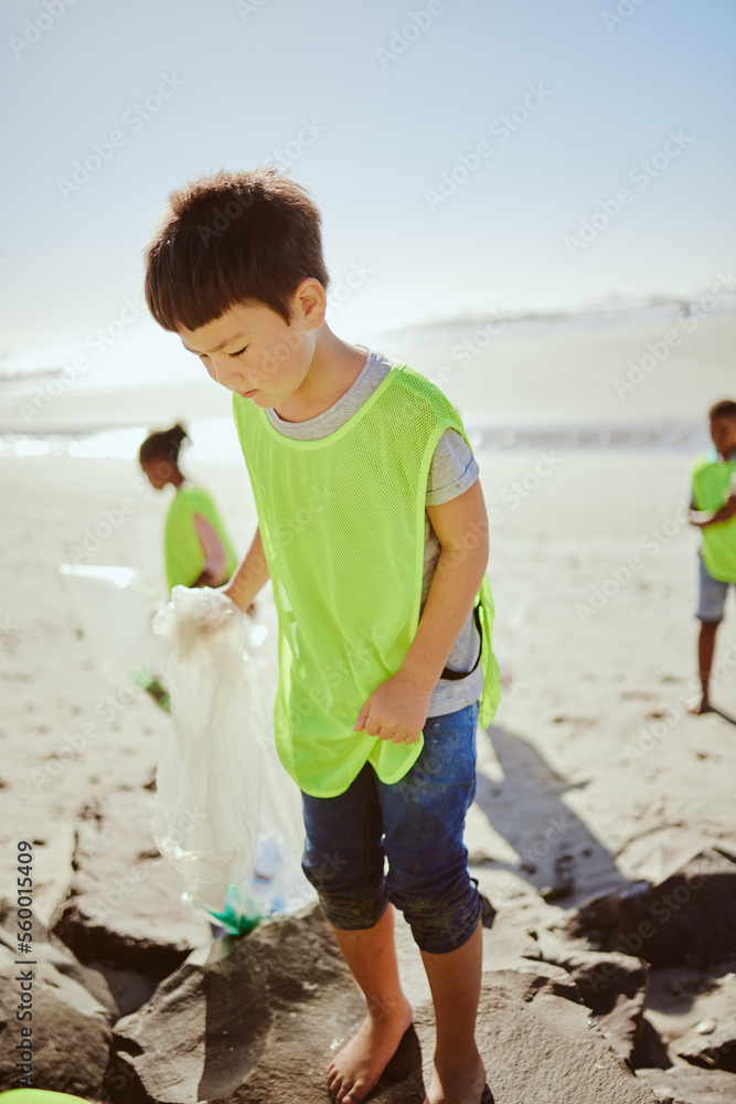 Environment, cleaning and children with pollution on beach for clean up, dirt and eco friendly volun