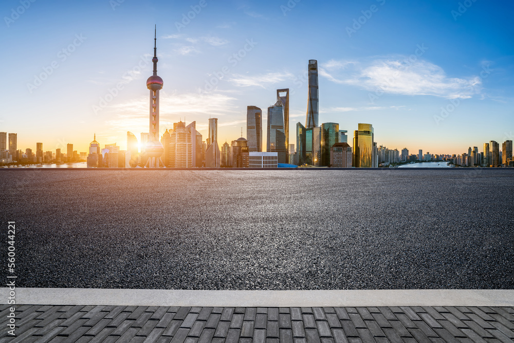 Asphalt road and city skyline with modern buildings at sunrise in Shanghai, China.