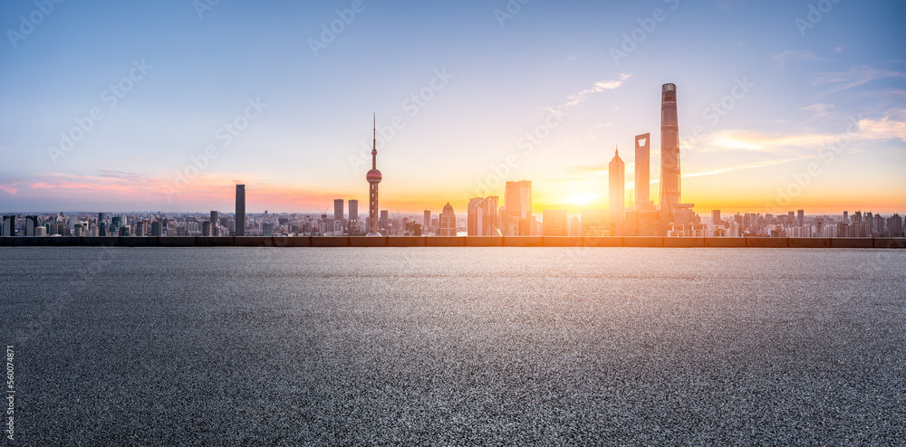 中国上海，日出时的柏油路和城市天际线，以及现代化的建筑。