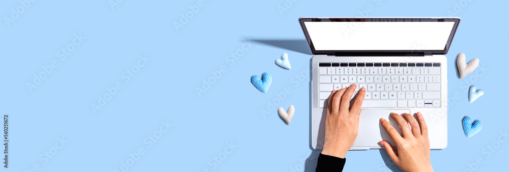 Laptop computer with heart cushions - flat lay