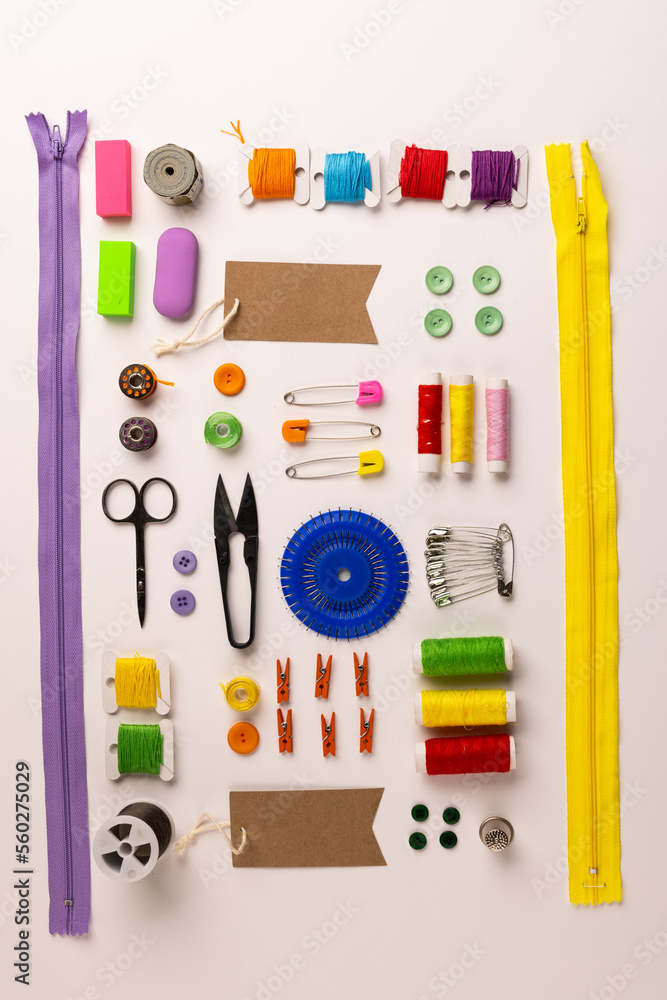 Image of sewing materials with scissors, buttons and threads on cream background