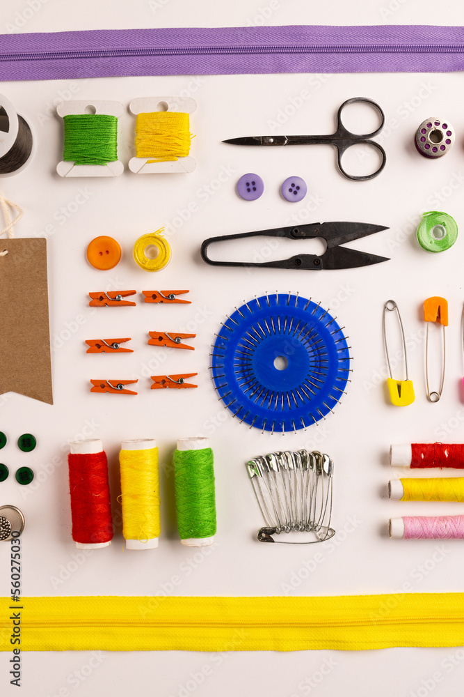 Image of sewing materials with scissors, buttons and threads on cream background