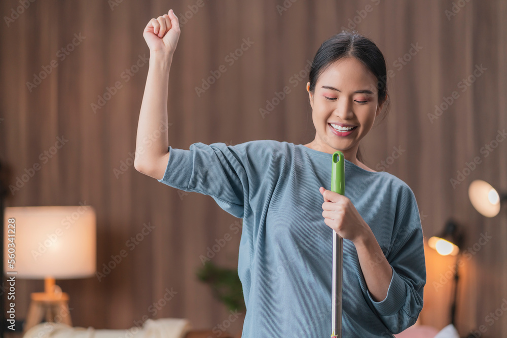 Happy young asian casually cloth woman housewife vacuuming and cleaning floor, singing with cheerful