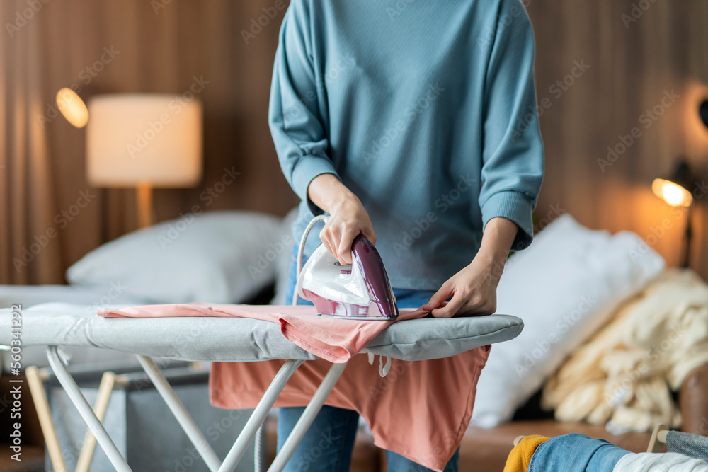 young asian adult female woman ironing her cloth at home,Portrait of a happy woman ironing her cloth