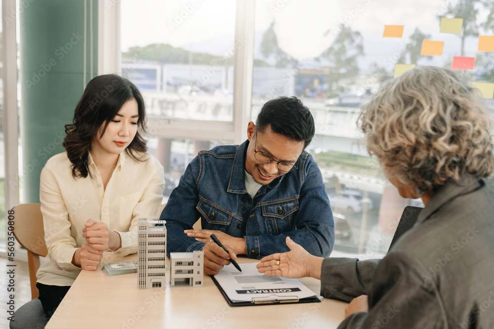 A family couple sign a lease meeting with a realtor or homeowner, purchase the first mortgage and mo