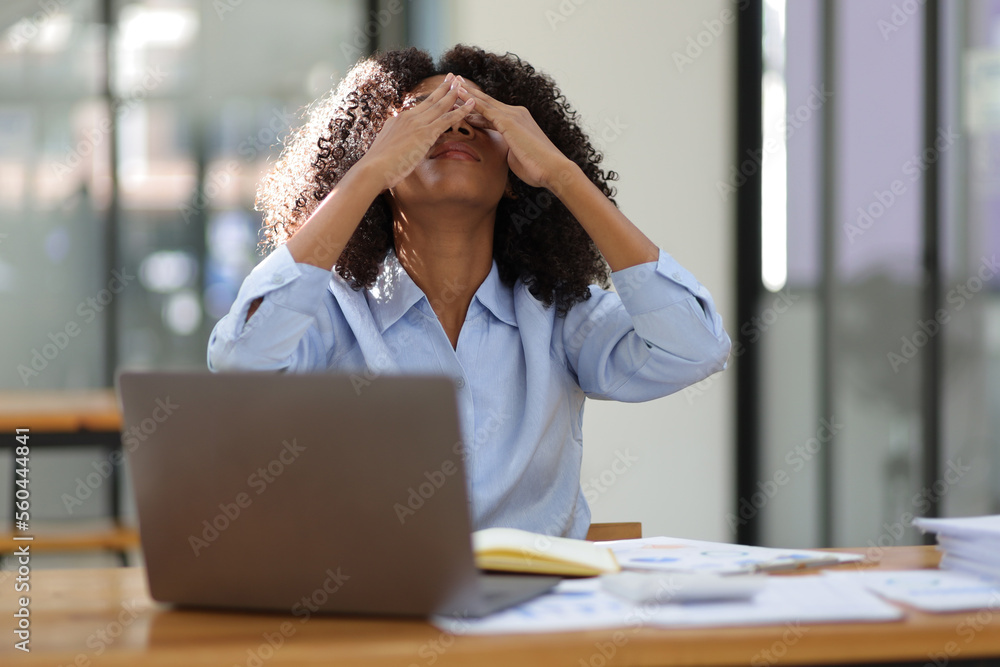 African woman in office stressed and worried about unsuccessfully working on deadlines. Stress and p