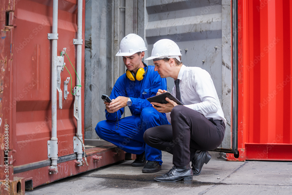 Businessman and engineer or Foreman checking the container to prepare the delivery to the customer.