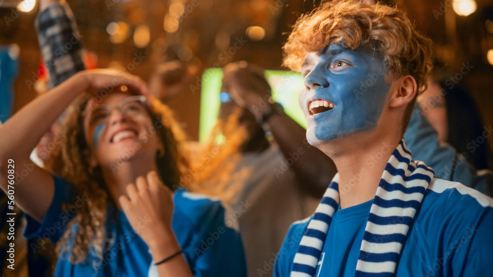 Group of Soccer Fans with Painted Faces Cheering, Screaming, Raising Hands and Jumping During a Foot