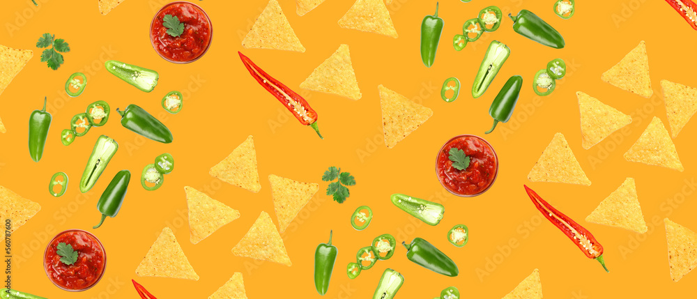 Tasty nachos with hot peppers, cilantro and salsa sauce on orange background