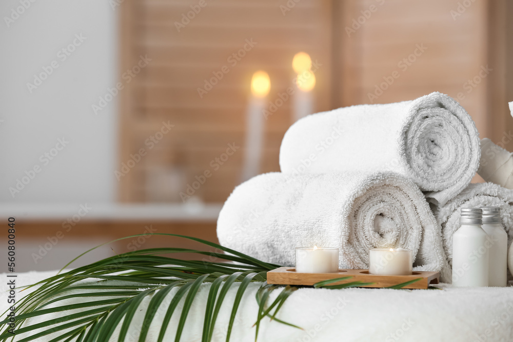 Spa composition with palm leaf on couch in salon, closeup