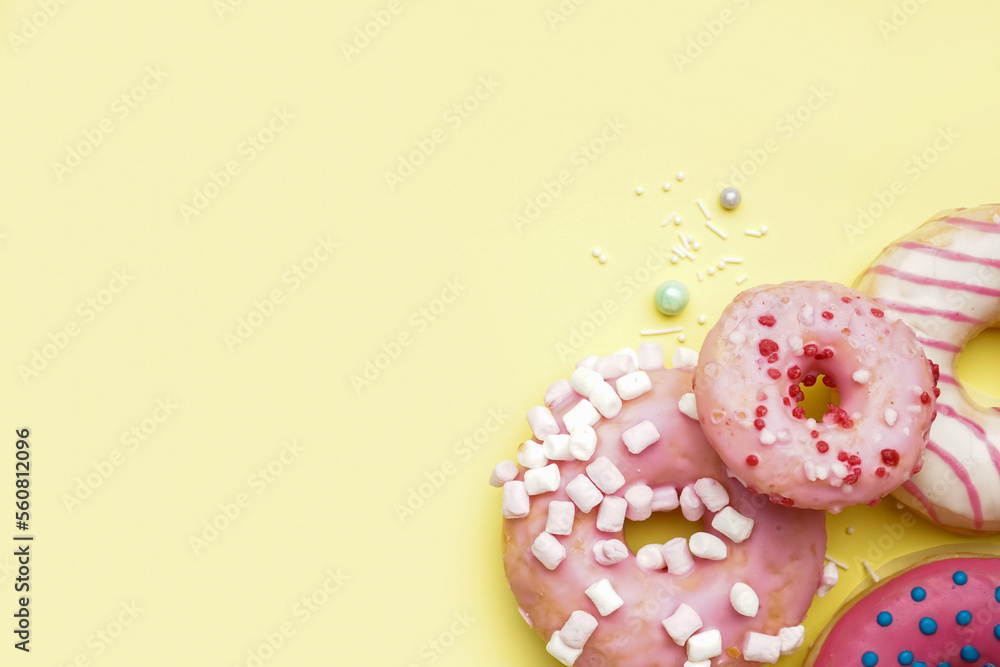 Tasty glazed donuts on yellow background