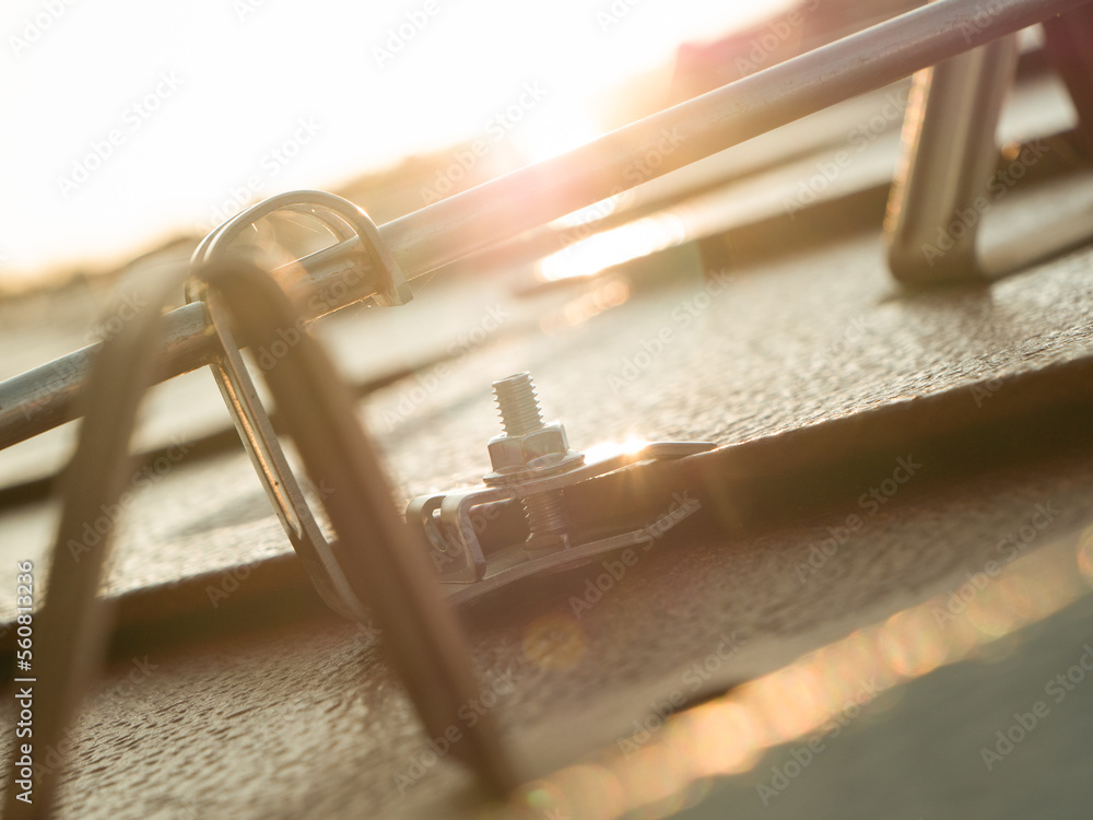 CLOSE UP, DOF: Golden sun beams reflecting from rooftop elements made from steel