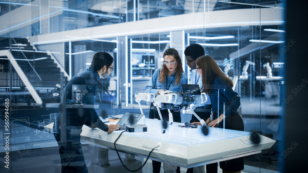 Diverse Colleagues Work in Industrial Robotics Factory, Experimenting With a Mobile Robot Prototype.